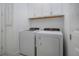 Modern laundry room featuring a white washer and dryer with overhead cabinets for ample storage at 6714 Alstead Cir, Bradenton, FL 34202