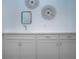 Bright laundry room with white cabinets, countertops, modern fixtures, and decor at 6714 Alstead Cir, Bradenton, FL 34202