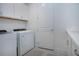 Modern laundry room with white washer and dryer, white cabinets, and wood accents at 6714 Alstead Cir, Bradenton, FL 34202