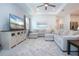 Bright living room features a tray ceiling, large sectional sofa, neutral tones, and an entertainment center with television at 6714 Alstead Cir, Bradenton, FL 34202