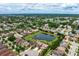 A neighborhood with numerous homes and a central pond, captured from an aerial perspective at 7020 Island Queen Ct, Sarasota, FL 34233