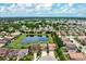 Aerial view of several homes that are adjacent to a large pond featuring a fountain at 7020 Island Queen Ct, Sarasota, FL 34233