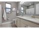 Well-lit bathroom features double sink vanity with granite countertop and decorative framed mirror at 7020 Island Queen Ct, Sarasota, FL 34233