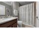Bathroom featuring a marble vanity top, and shower with patterned curtain at 7020 Island Queen Ct, Sarasota, FL 34233