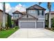 Charming two-story home featuring a gray stucco exterior, red tile roof, and meticulously landscaped front yard at 7020 Island Queen Ct, Sarasota, FL 34233