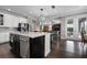 Modern kitchen with stainless steel appliances and hardwood flooring, that connects to the living room at 7020 Island Queen Ct, Sarasota, FL 34233