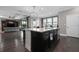 Kitchen island with granite countertop and dark wood cabinets open to the living room at 7020 Island Queen Ct, Sarasota, FL 34233