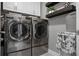 Well-equipped laundry room with stainless steel washer and dryer, white cabinets, and decor at 7020 Island Queen Ct, Sarasota, FL 34233