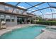 A spacious screened pool with a hot tub, outdoor kitchen, and an expansive patio at 7020 Island Queen Ct, Sarasota, FL 34233