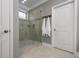 Tiled shower with glass door, tiled floor, and neutral-toned walls and fixtures at 7020 Island Queen Ct, Sarasota, FL 34233