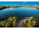 Aerial view of a wooden boardwalk leading into a tranquil body of water, surrounded by lush vegetation at 715 Fontana Ln, Bradenton, FL 34209