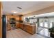 Open kitchen with stainless steel appliances, light wood cabinets and pool views through the french doors at 715 Fontana Ln, Bradenton, FL 34209