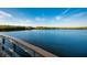 Scenic water view from a wooden pier with blue waters, lush trees, and a bright, partly cloudy sky at 715 Fontana Ln, Bradenton, FL 34209