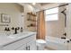 Updated bathroom with a white vanity, modern fixtures, decorative floating shelves and shower-tub combo at 730 Old Quarry Rd, Bradenton, FL 34212