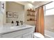 Well-lit bathroom featuring a white vanity, modern fixtures, decorative floating shelves and shower-tub combo at 730 Old Quarry Rd, Bradenton, FL 34212