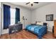 Cozy bedroom featuring blue bedding, a ceiling fan, a desk, and warm hardwood floors at 730 Old Quarry Rd, Bradenton, FL 34212