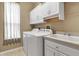 Bright laundry room with white cabinets, washer, dryer, and sink at 730 Old Quarry Rd, Bradenton, FL 34212