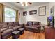Comfortable living room featuring hardwood floors, two leather sofas, and bright, arched window at 730 Old Quarry Rd, Bradenton, FL 34212
