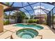 Screened-in pool area featuring a freeform pool, spa, and lush landscaping at 730 Old Quarry Rd, Bradenton, FL 34212