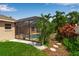 Exterior view of pool cage from the side of the yard, with tropical plants at 730 Old Quarry Rd, Bradenton, FL 34212