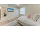 Well-lit bedroom with light hardwood floors features a TV, closet, and comfortable bed at 7327 38Th Court East, Sarasota, FL 34243
