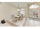 Elegant dining room with a contemporary light fixture, white table setting, and tiled floors at 7327 38Th Court East, Sarasota, FL 34243