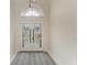 Bright entryway featuring a front door with sidelights, complemented by a modern chandelier and a tiled floor at 7327 38Th Court East, Sarasota, FL 34243