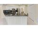 Bright kitchen featuring white cabinets, black backsplash, stainless steel appliances, and granite countertops at 7327 38Th Court East, Sarasota, FL 34243