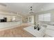 Open-concept living room with wood floors, white sectional, and a view of the kitchen counter at 7327 38Th Court East, Sarasota, FL 34243