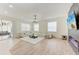 Bright, open living room featuring a modern fireplace, sleek lighting, and a comfortable white sectional sofa at 7327 38Th Court East, Sarasota, FL 34243