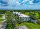 Birds-eye view of condo building near green landscape, trees, and a body of water at 7461 W Country Club N Dr # 203, Sarasota, FL 34243