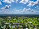 Aerial view of condo community surrounded by lush greenery, golf course, and picturesque scenery at 7461 W Country Club N Dr # 203, Sarasota, FL 34243