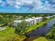 Aerial view of condo building shows a tranquil setting near water and mature trees at 7461 W Country Club N Dr # 203, Sarasota, FL 34243