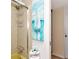 Bathroom featuring a yellow tiled shower, sailboat art, and corner toiletries shelf at 7461 W Country Club N Dr # 203, Sarasota, FL 34243