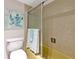 Bathroom with a shower/tub combo with tile surround, toilet, and coastal decor at 7461 W Country Club N Dr # 203, Sarasota, FL 34243