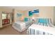 Sunlit bedroom with two beds, coastal artwork, and ample closet space at 7461 W Country Club N Dr # 203, Sarasota, FL 34243