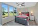 Bright bedroom features a ceiling fan and large windows with scenic golf course and water views at 7461 W Country Club N Dr # 203, Sarasota, FL 34243