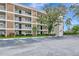 Exterior view of condo building featuring multiple floors with balconies, well-maintained landscaping, and ample parking at 7461 W Country Club N Dr # 203, Sarasota, FL 34243