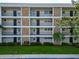 A multi-story condominium with beige exterior and stone accents, each unit has a small balcony at 7461 W Country Club N Dr # 203, Sarasota, FL 34243