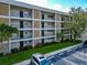 Three-story condo building featuring stone accents, balconies, and well-maintained landscaping at 7461 W Country Club N Dr # 203, Sarasota, FL 34243