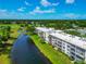 Condo building along a waterway surrounded by green spaces, mature trees, and a beautiful golf course at 7461 W Country Club N Dr # 203, Sarasota, FL 34243