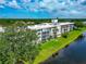 Modern multi-story condo building showcasing a waterfront view and beautifully landscaped grounds at 7461 W Country Club N Dr # 203, Sarasota, FL 34243