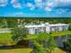Waterfront condo building featuring balconies, and surrounded by lush landscaping, and tranquil water views at 7461 W Country Club N Dr # 203, Sarasota, FL 34243