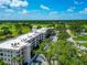 Condo building featuring a rooftop, well-maintained landscaping, a parking lot and a golf course nearby at 7461 W Country Club N Dr # 203, Sarasota, FL 34243