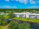 Waterfront condo building featuring balconies, and surrounded by lush landscaping, and tranquil water views at 7461 W Country Club N Dr # 203, Sarasota, FL 34243