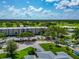 Condo building featuring a canopy, well-maintained landscaping, and parking, near a well-manicured golf course at 7461 W Country Club N Dr # 203, Sarasota, FL 34243