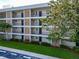 Condominium building showcasing balconies, tidy landscaping, and convenient parking spaces at 7461 W Country Club N Dr # 203, Sarasota, FL 34243