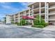 Inviting exterior view of the condo building featuring a covered entrance and well-maintained landscaping at 7461 W Country Club N Dr # 203, Sarasota, FL 34243
