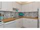 Bright kitchen with ample counter space, white cabinets, and decorative tile backsplash at 7461 W Country Club N Dr # 203, Sarasota, FL 34243