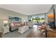 Charming living room featuring ample seating, stylish decor, and a view of the outdoors through sliding glass doors at 7461 W Country Club N Dr # 203, Sarasota, FL 34243